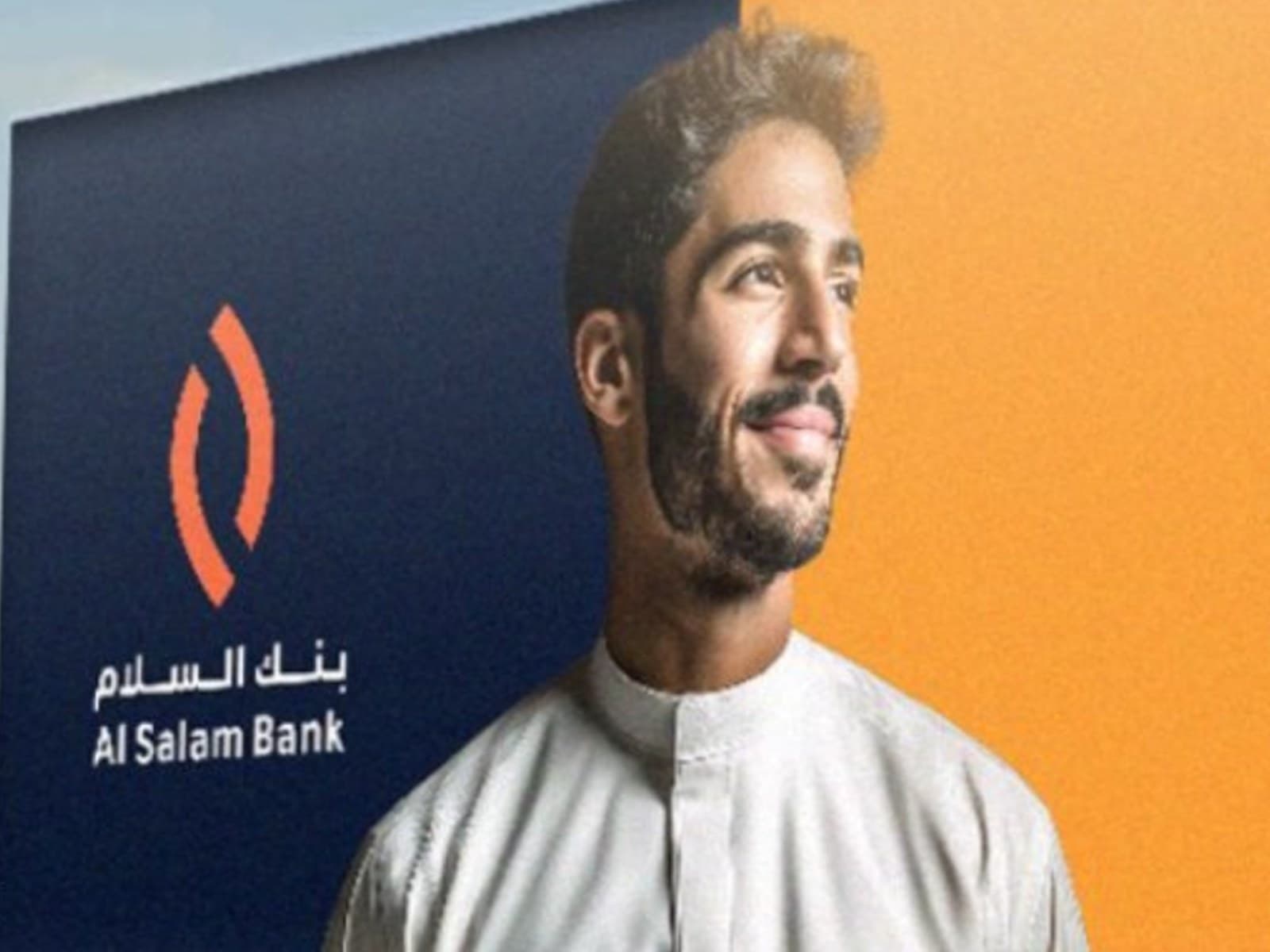An orange roadside billboard for Al Salam Bank's financing offer, in Arabic, above a highway