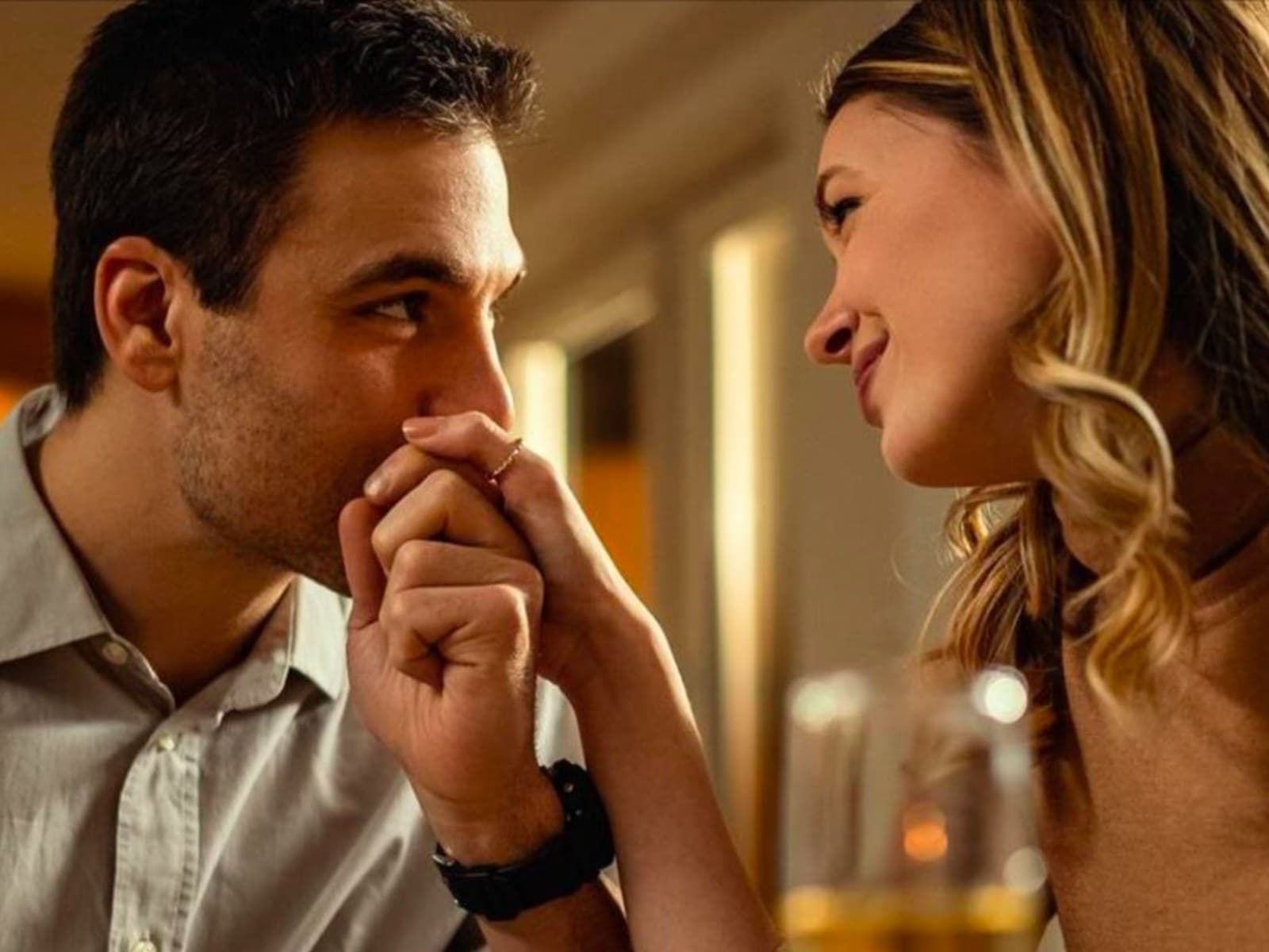 A couple dining at a restaurant, with an American Express Gold Card shown alongside