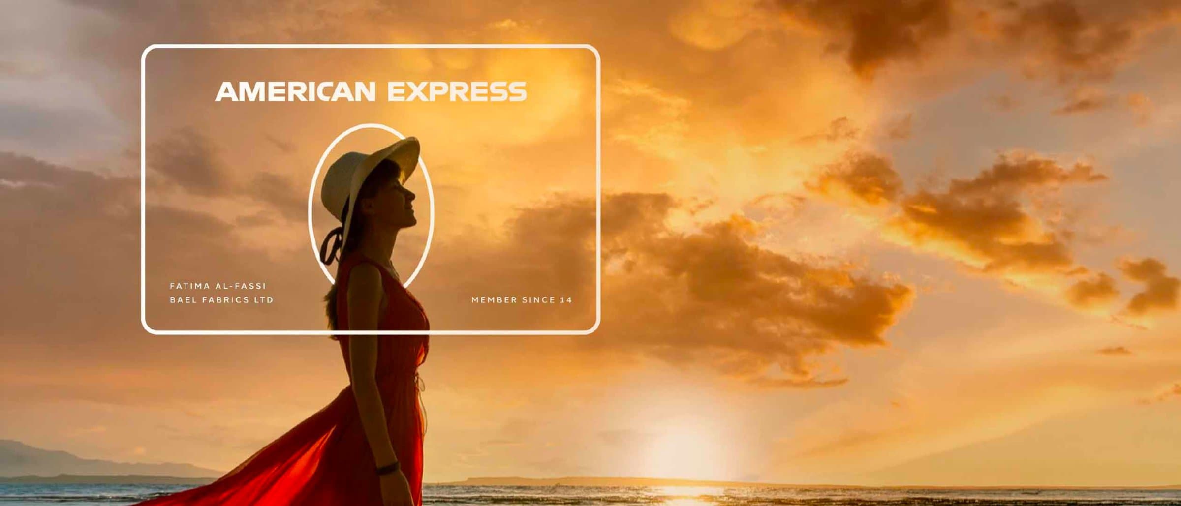 A woman in a red dress on a beach at sunset, with an American Express card graphic