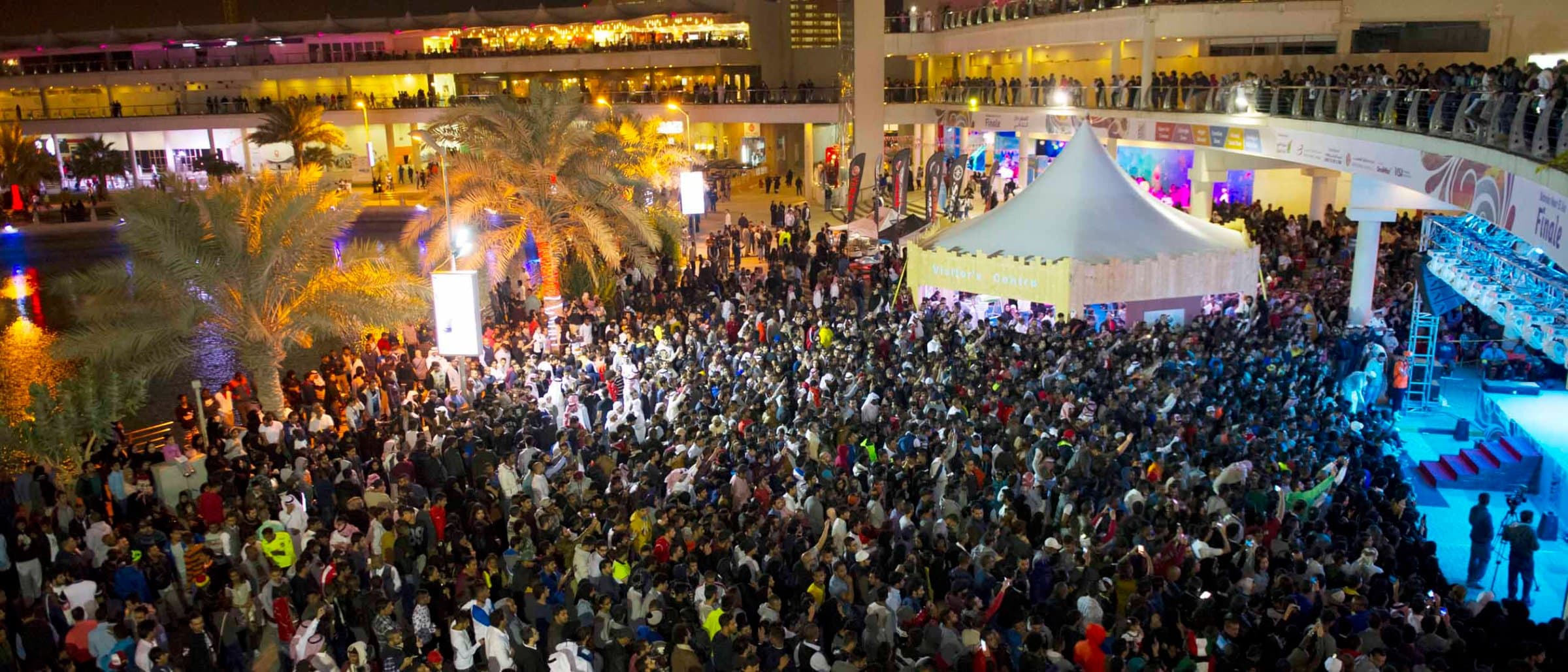An aerial view of a large night-time crowd at the Bahrain Noor El Ain festival